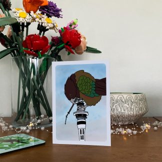 Kea nui greeting card on a wooden sideboard.