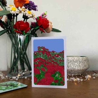 Pōhutukawa greeting card displayed on a sideboard with decorative items.